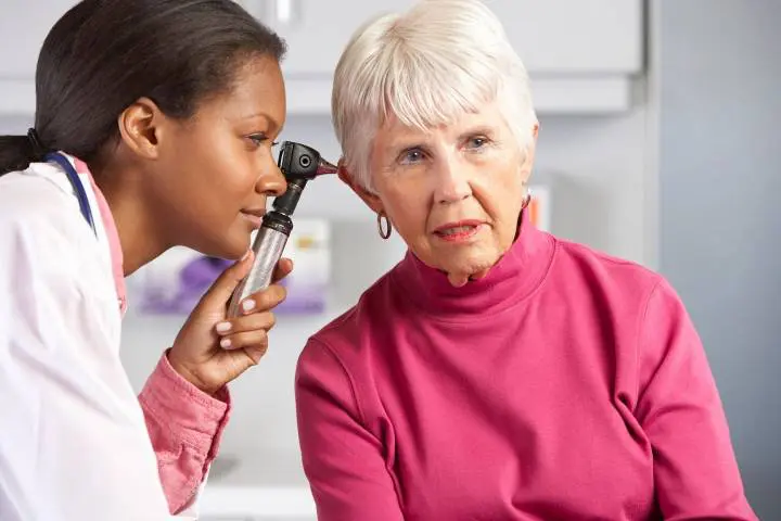 Doctor Examining Senior Female Patient's Ears