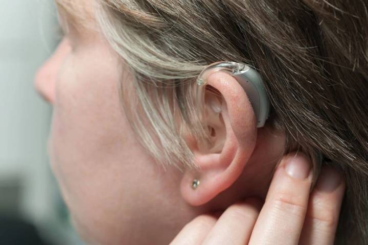 Women keeping Hearing Aid In Ear